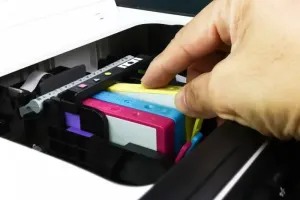 Laptop na biurku z wykresem wydajności Windows, pokazującym 100% obciążenie dysku w spokojnym biurze domowym.